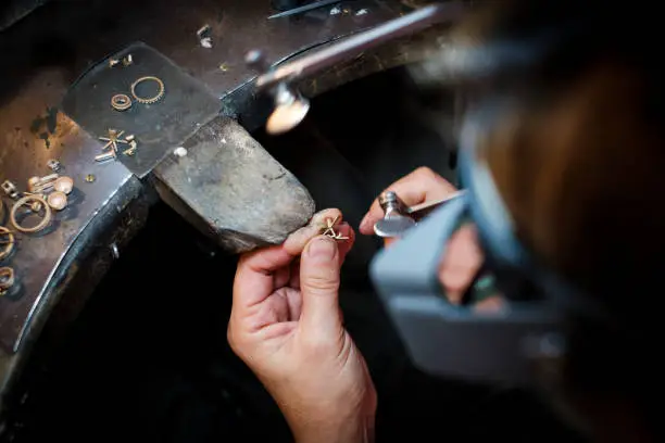 Bijutierul la lucru în studioul său atelier de confecții bijuterii